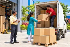শ্ৰমিকসকলে গুদামৰ পৰা কাৰ্টন মালবাহী ট্ৰাকত তুলিছে।
